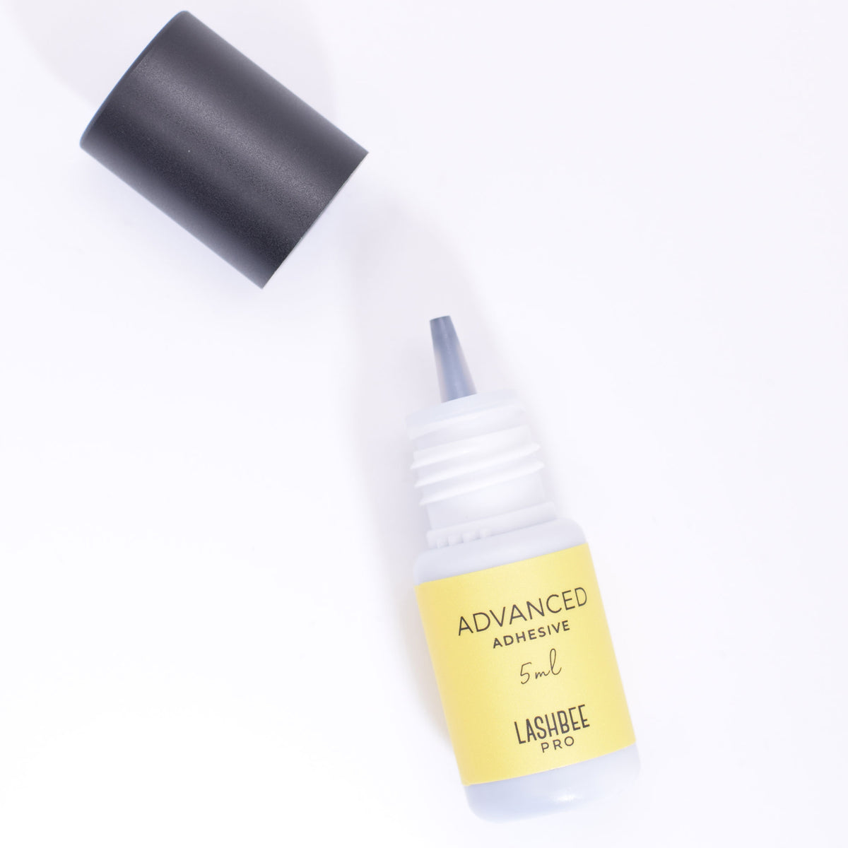 LashBeePro Advanced Adhesive for eyelash extensions - yellow bottle with the black cap off to show the bottle nozzle